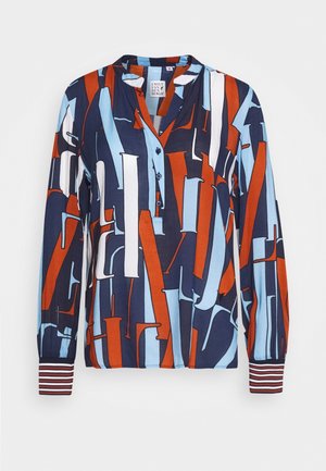 Long-sleeve blouse with geometric abstract print in navy, rust, white, and light blue, featuring buttoned neckline and striped cuffs.