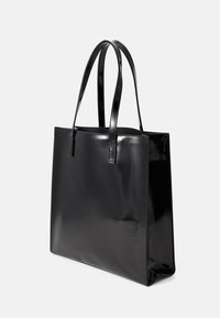 Sac fourre-tout noir brillant avec deux longues poignées, de forme rectangulaire, surface lisse et sans matériel ni embellissements visibles.