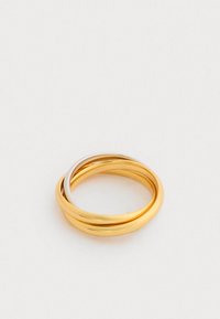 Kuld- ja hõbedased keerdsõrmused, siledad ja ümarad, millel on poleeritud viimistlus ja minimalistlik disain.