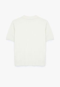 Kortærmet strikket polo i off-white, med en klassisk krave og ribbet manchetter, glat overflade og en tætsiddende silhuet.