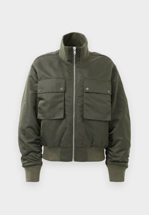 Bomber bunda v tmavě olivově zelené barvě s předním zipem, dvěma velkými klopovými kapsami se západkami, žebrovanými manžetami, límcem a páskem.