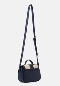 Borsa a mano in pelle blu navy con patta in paglia intrecciata, forma arrotondata, tracolla regolabile e manico superiore. Sono presenti dettagli in metallo dorato.