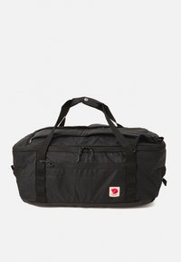 Black nylon duffel bag with zippered compartments and a logo tag. Features two sturdy handles and adjustable shoulder straps. Smooth texture.