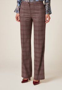 Pantalones de cuadros de pierna ancha en burdeos con un sutil patrón de check, confeccionados en una tela texturada. Cuentan con un cierre de botón y bolsillos.