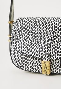 Zwart-wit gevlekte leren handtas met een klep sluiting, gouden hardware en "PINKO" gegraveerde accenten. Beschikt over een textuur oppervlak.