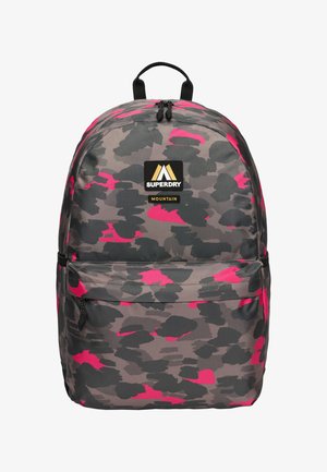 Plecak w wzór camouflage w odcieniach szarości z różowymi akcentami, wykonany z trwałego materiału. Posiada uchwyt u góry oraz kieszeń na zamek z przodu na dodatkowe przechowywanie.