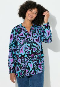 Langärmlige Bluse aus schwarzem Stoff mit einem mehrfarbigen Herzmuster in Lila und Türkis. Verfügt über einen V-Ausschnitt und eine lockere Passform.