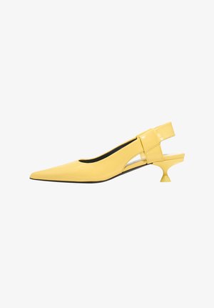 Geltona patentinė oda slingback avalynė su smailiu pirštu, unikalia išpjovos detale šone ir mažu, apvaliu kulnu.