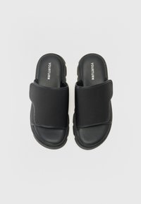 Black slide sandals with a cushioned footbed, fabric upper band, and textured sole. Features a brand logo on the top.