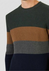 Ribbed sweater featuring horizontal stripes in dark green, brown, gray, and navy. Crew neck design with textured fabric.