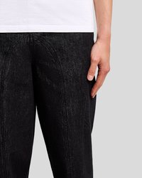 Juodi džinsai su tekstūrine apdaila, su išlenkta siūlės detalėmis priekyje ir šoninėse kišenėse. Suderinti su balta marškinėliais.