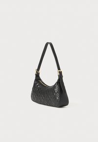 Black quilted leather shoulder bag with a curved shape, gold-tone hardware, and a single adjustable strap. Smooth texture and zip closure.
