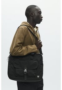 Borsa messenger nera con tasca frontale, tracolla regolabile e chiusura a fibbia. Texture liscia, design minimalista con dettaglio logo.