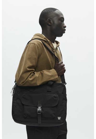 Sac messager noir avec une poche frontale, une sangle réglable et une fermeture à boucle. Texture lisse, design minimaliste avec détail logo.