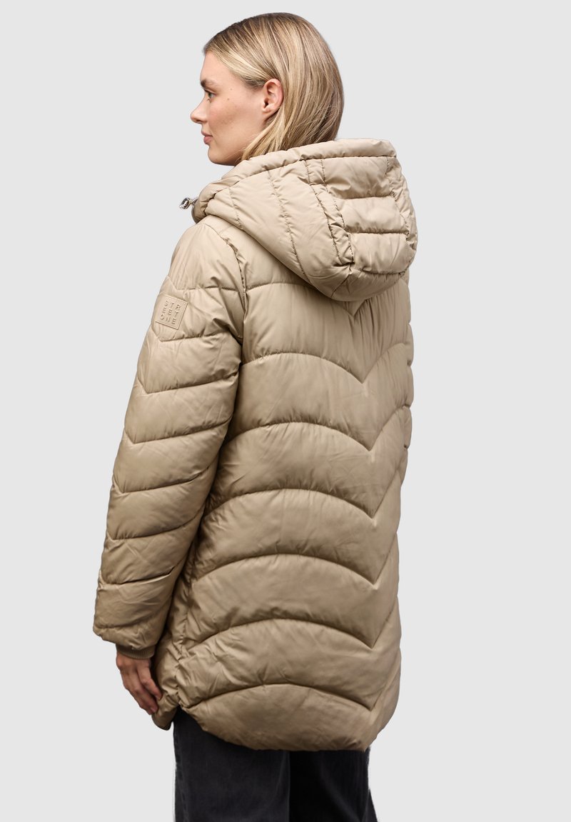Beige polstret jakke med hætte, chevron quiltet mønster og et logo patch på venstre ærme. Glat tekstur, hofte-længde design.