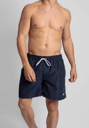 Donkerblauwe zwembroek met een elastische tailleband, verstelbare trekkoord en een klein logo detail aan de zijkant. Gladde textuur, casual ontwerp.