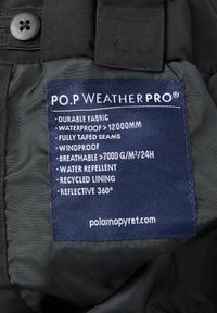 Zwarte stoffen label met blauwe tekst die de kenmerken opsomt: duurzaam, waterdicht, winddicht, ademend, waterafstotend, gerecycled voering, reflecterend.