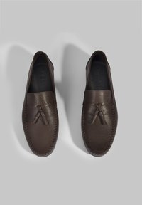 Braune Lederloafers mit strukturiertem Finish, ausgestattet mit einer dekorativen Quaste und kontrastierenden Nähten entlang der Kanten. Glattes Innenfutter.