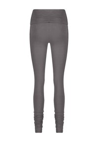 Grå leggings med hög, draperad midja. Tillverkade av mjukt, elastiskt material, med åtsittande ben och skräddade ärmslut vid anklarna.