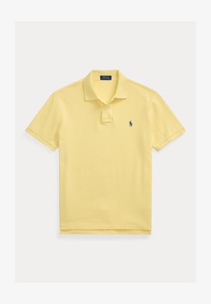 Világos sárga, rövid ujjú galléros póló, kétgombos léccel és kis sötétkék hímzett logóval a mellrészen.