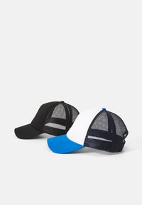 Dos gorras de camionero: una negra con un frente negro sólido y parte trasera de malla; una blanca con visera azul y parte trasera de malla.