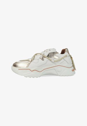 Witte en gouden chunky sneaker met dikke zool, decoratieve metalen accenten en veter in touwstijl die losjes om de schoen is gestrikt.