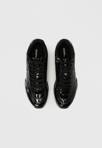 Μαύρα, γυαλιστερά αθλητικά παπούτσια με ομαλή υφή, διαθέτουν κλείσιμο με κορδόνια και επενδεδυμένο γιακά. Το λογότυπο είναι ορατό στις εσωτερικές σόλες.