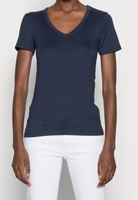 Camiseta de manga corta en azul marino con diseño de escote en V. Fabricada en tejido suave, presenta una forma ajustada y un estilo elegante y minimalista.