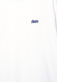 Hvid kortærmet t-shirt lavet af bomuld, med et lille broderet logo i marineblå i det øverste venstre hjørne. Glat tekstur, rund hals.