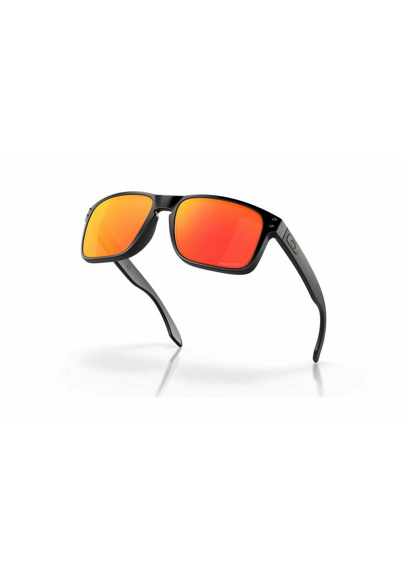 Lunettes de soleil noires avec des montures rectangulaires et des verres miroités rouges. Présente une finition lisse et brillante, avec des accents latéraux distinctifs.