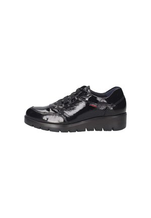 Zapatillas de piel sintética negra con punta redonda, diseño de cordones y suela acolchada. Presenta una marca sutil en el lateral.