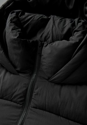 Must must jacket kõrge kaelusega, sileda ja mati tekstuuriga; keskne tõmblukk ja tšekitud disain sooja hoidmiseks.