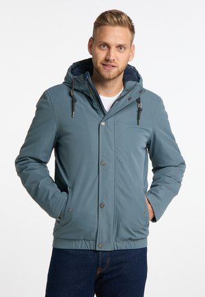 Herren Kapuzenjacke in gedämpftem Blau, mit einem Reiß- und Druckknopfverschluss, seitlichen Taschen und einem elastischen Bund. Glatte Textur.