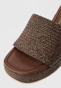 Bruine geweven wedge sandaal met een textuur, gevlochten bovenwerk en een soepele leren voetbed met een platte teenriem.