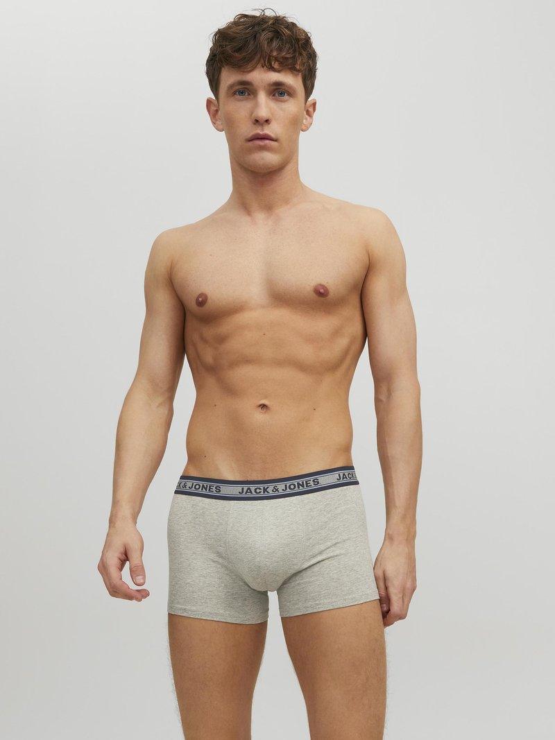 Graue Baumwoll-Boxershorts mit einem marineblauen elastischen Bund, der den Schriftzug "JACK & JONES" trägt. Der Stoff hat eine glatte Textur.