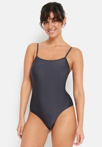 Zwart eendelig badpak met dunne bandjes, een gladde textuur, hoge beenopeningen en een minimalistisch ontwerp. Geschikt voor zwemmen of strandkleding.