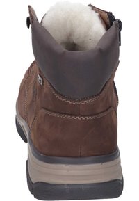 Bota de ante marrón con un cuello acolchado marrón, suela texturizada gris y detalles lisos en gris. Cierre con cremallera en el lateral para un fácil acceso.