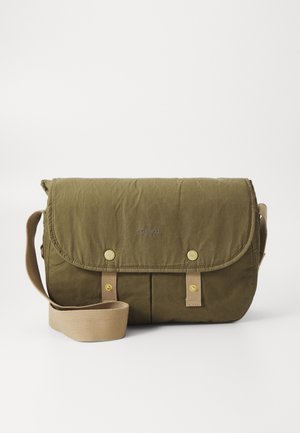 Sac bandoulière vert olive avec rabat fermé par deux boutons-pression dorés et sangle beige ajustable, présenté sur fond blanc.