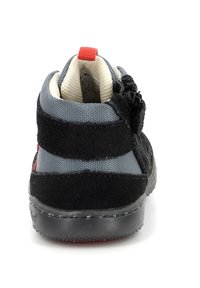Zapatillas altas en negro y gris con parte superior de ante y textil, suela de goma, tira roja en el talón y cremalleras laterales para un acceso fácil.