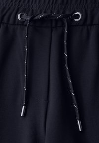 Marineblauwe joggingbroek van gladde stof, met een elastische tailleband, een trekkoord met metalen uiteinden en een zijzakdetail.