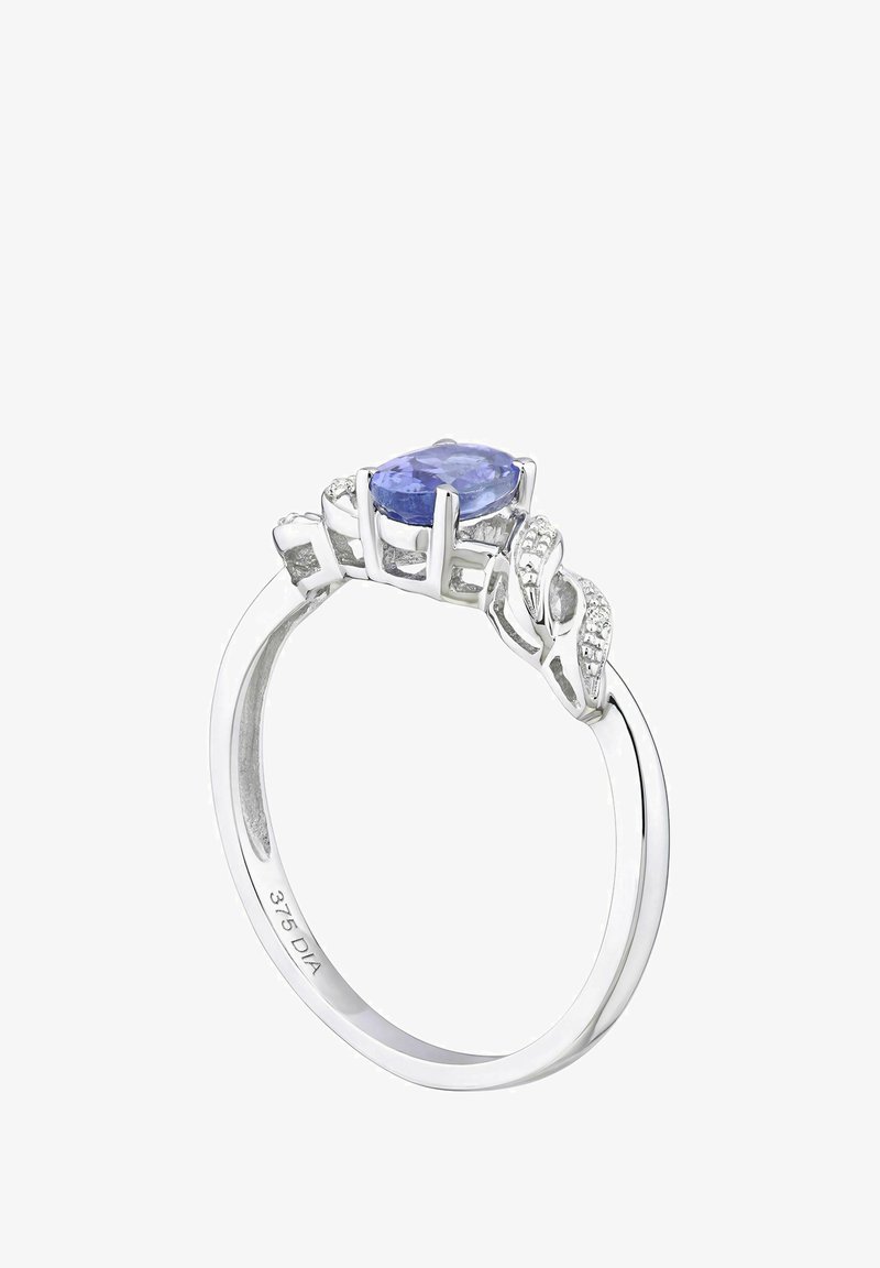 Hopea rengas, jossa on ovaali tanzaniittikeskuskivivä, ympärillä timanttiaksentteja; monimutkainen lehtimäinen muotoilu rengaspinnalla.