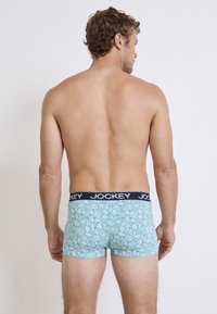 Herrens boxer briefs i ljusblått med ett blommönster. Har en svart Jockey midja och en åtsittande design för komfort.