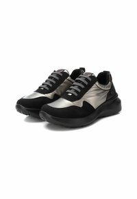 Las zapatillas negras y plateadas metálicas presentan una combinación de materiales lisos y texturados, con una suela acolchada y cordones en contraste.