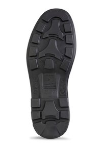 Black rubber shoe sole with a textured surface, featuring various tread patterns and embossed manufacturer details.