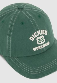 Vihreä puuvillainen baseball-lippalakki, jossa on brodeerattu "DICKIES 22 WORKWEAR". Varustettu valkoisilla ompeleilla ja ilmanreiki�ä sivuilla. Perinteinen kaareva lippa.
