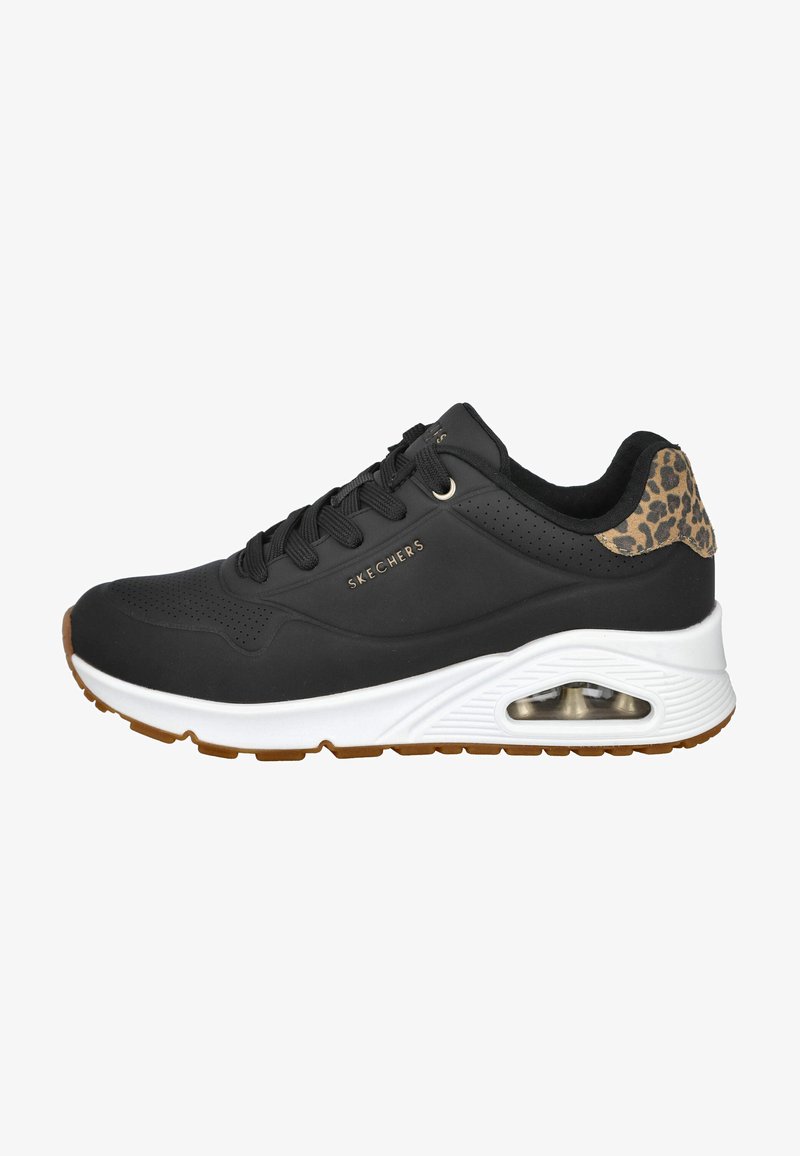 Zapatilla negra con parte superior texturizada negra y acento de estampado de leopardo en el talón. Presenta una entresuela blanca y suela de goma con unidad de aire visible.