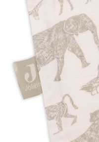 Tissu en coton présentant un fond beige clair avec des silhouettes d'animaux en beige plus foncé. Une petite étiquette avec le logo "Jolie.n" est visible.