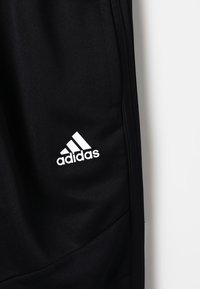 Schwarze Sporthosen mit strukturierter Oberfläche, mit einem weißen Adidas-Logo auf der linken Seite. Entwickelt für Komfort und Bewegungsfreiheit.