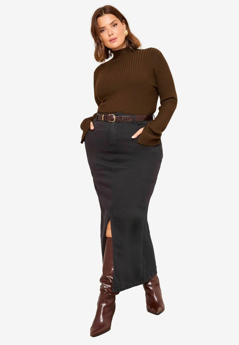 Čierna džínsová maxi sukňa s predným rozparkom, kombinovaná s tmavohnedým rebrovaným rolákom a hnedými čižmami s vysokým podpätkom a špicatou špičkou po kolená.