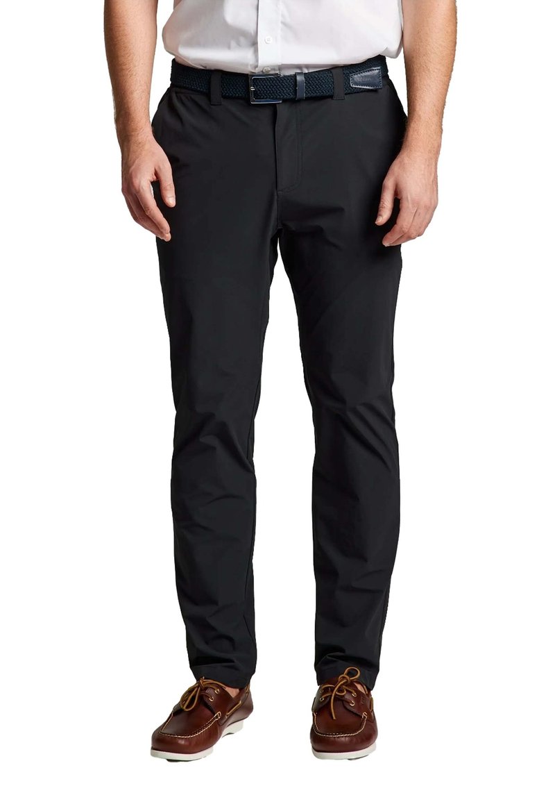 Pantalons noirs pour hommes en tissu lisse et léger, avec une coupe slim et des poches avant discrètes, associés à des chaussures bateau marron.